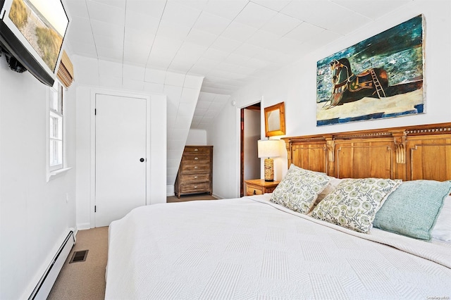 carpeted bedroom with a baseboard heating unit