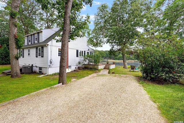 view of side of home with central AC and a lawn