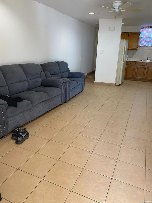 living room featuring light tile patterned floors, ceiling fan, and sink