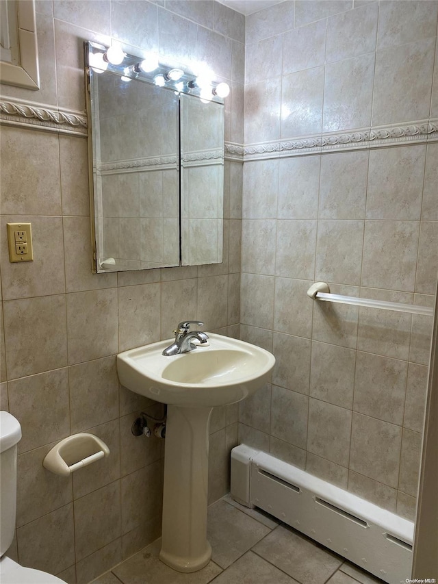 bathroom featuring tile patterned floors, toilet, tile walls, and a baseboard radiator