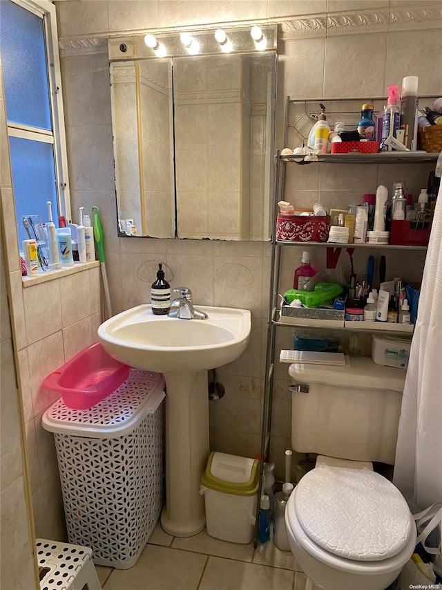 bathroom featuring tile patterned floors, tile walls, and toilet