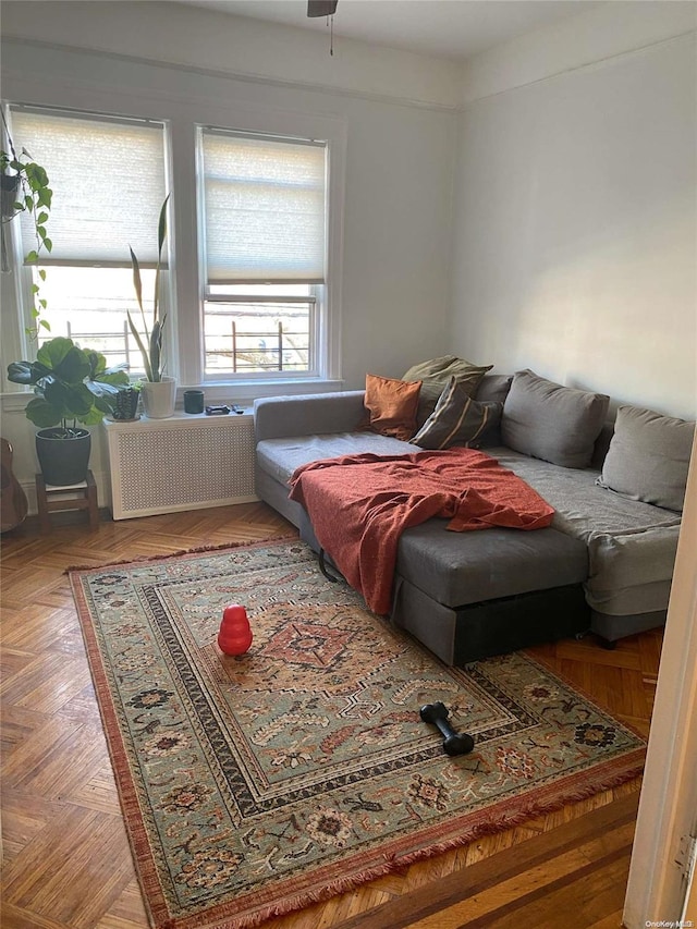 living room with ceiling fan, parquet floors, and radiator heating unit