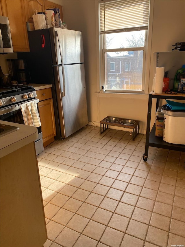 kitchen featuring light tile patterned floors and stainless steel appliances