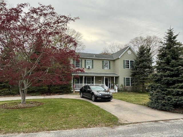 10 Coolidge Rd, Hampton Bays, NY 11946 - view of front facade featuring covered porch, driveway, and a front lawn