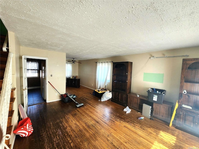 unfurnished living room featuring hardwood / wood-style flooring, ceiling fan, and a textured ceiling