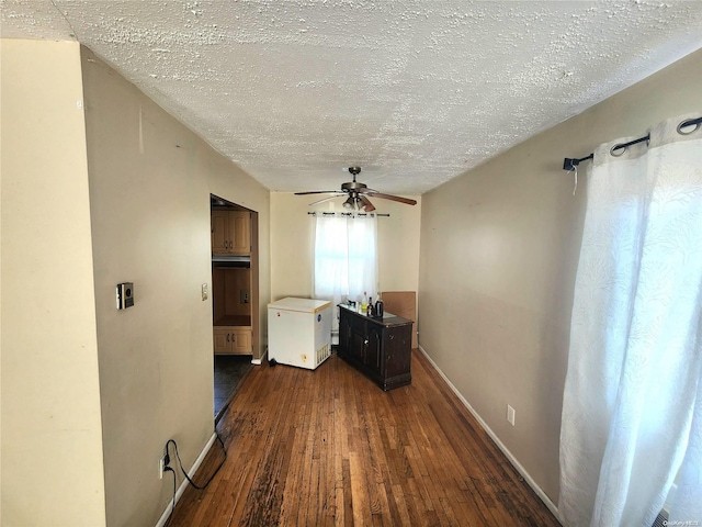 hall featuring a textured ceiling and dark hardwood / wood-style floors