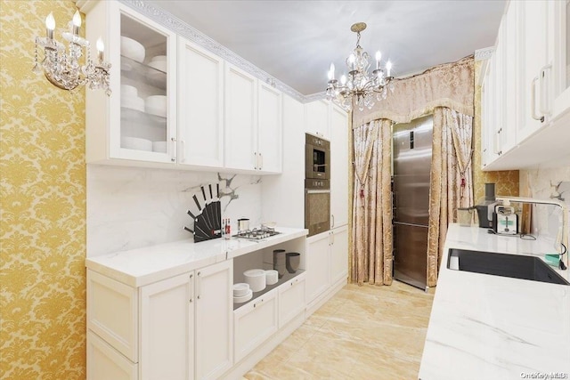 kitchen featuring white cabinets, decorative light fixtures, stainless steel appliances, and an inviting chandelier