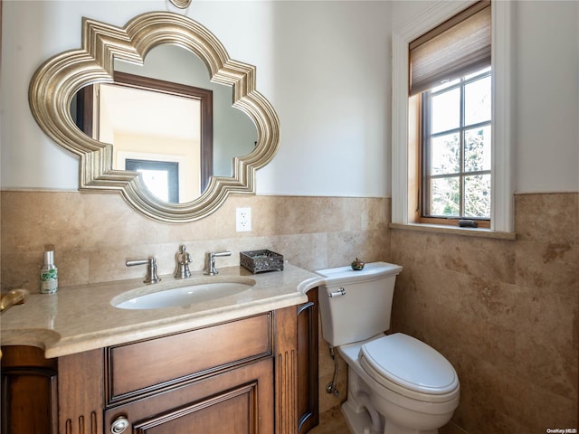 bathroom featuring vanity, toilet, and tile walls