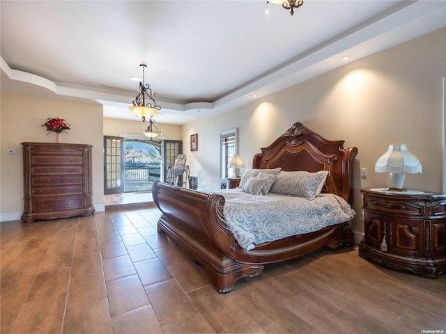 bedroom with a tray ceiling and access to exterior