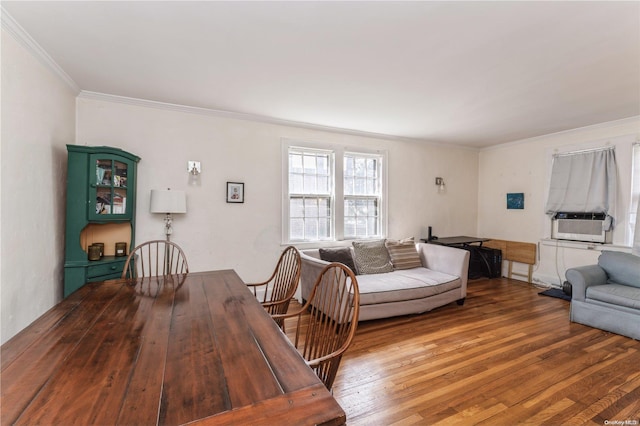 living room with cooling unit, wood-type flooring, and crown molding