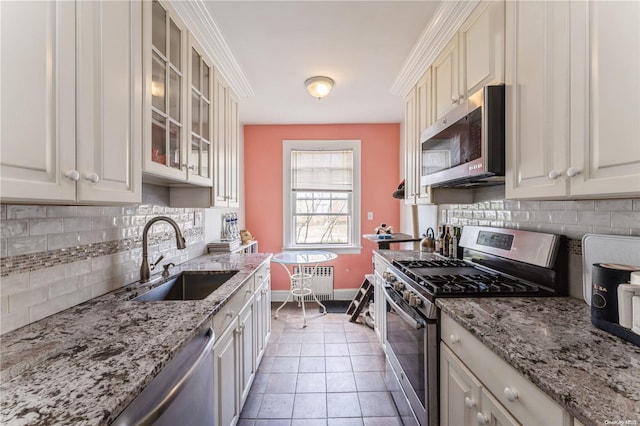 kitchen with light tile patterned floors, stainless steel appliances, tasteful backsplash, and sink