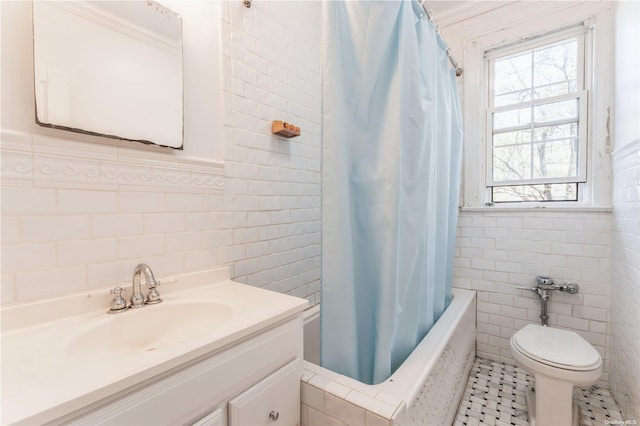 full bathroom featuring tile patterned floors, vanity, shower / bath combo with shower curtain, tile walls, and toilet