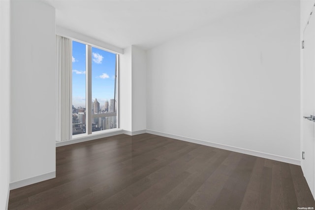 unfurnished room with dark hardwood / wood-style flooring