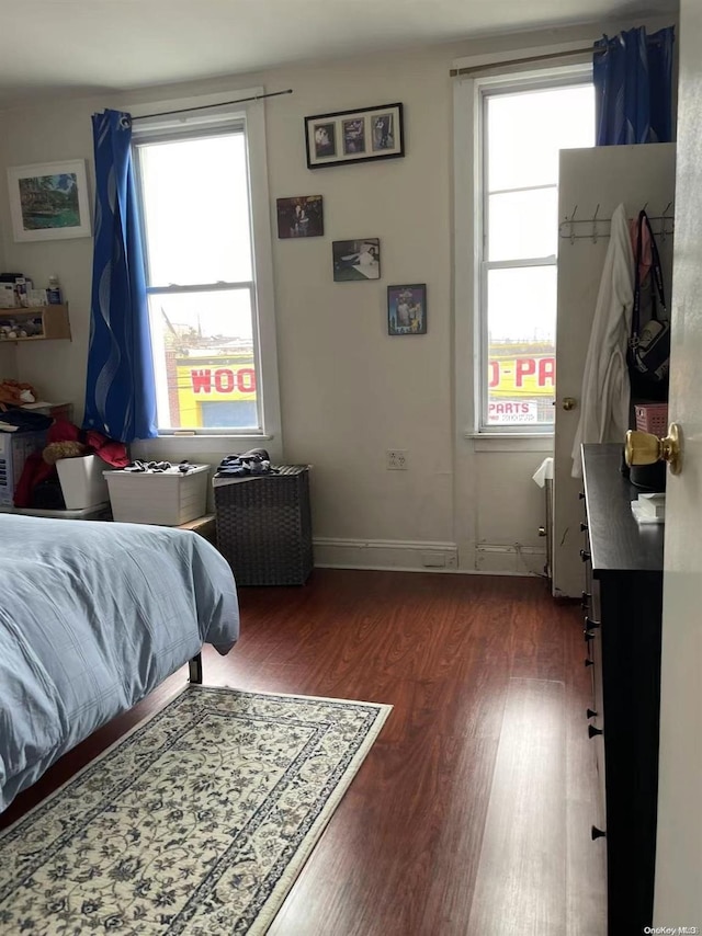 bedroom with dark hardwood / wood-style flooring