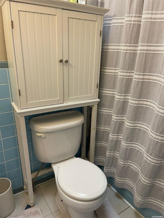 bathroom with tile patterned flooring, tile walls, and toilet