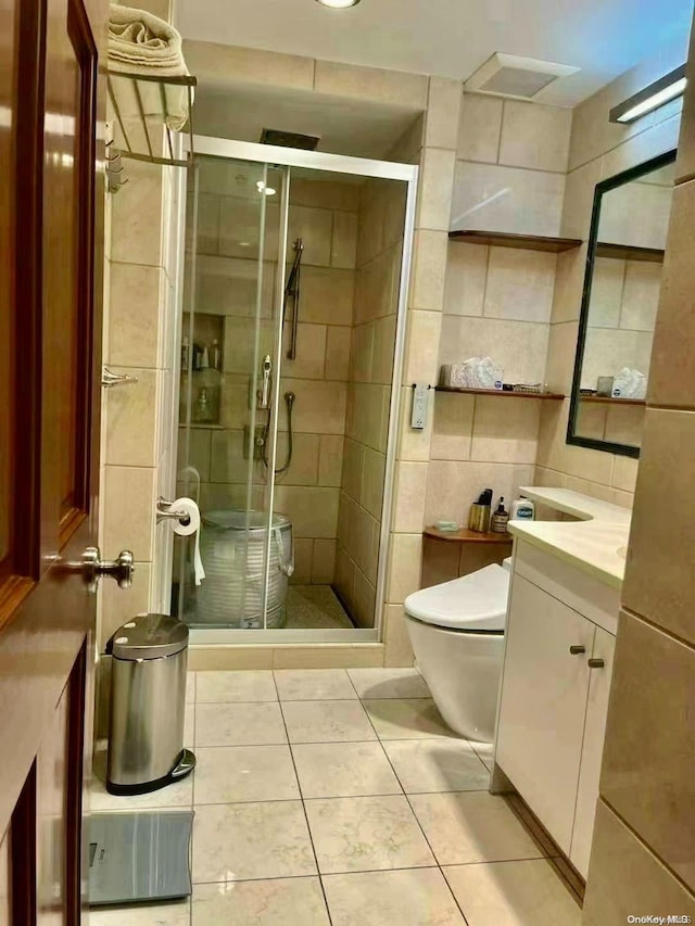 bathroom featuring tasteful backsplash, tile patterned floors, vanity, toilet, and a shower with shower door