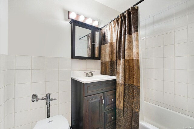 full bathroom with shower / bath combination with curtain, vanity, toilet, and tile walls