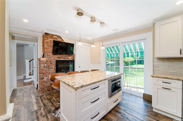 kitchen with plenty of natural light, a kitchen bar, decorative light fixtures, dark hardwood / wood-style flooring, and white cabinetry