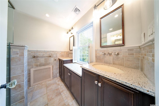 bathroom with vanity and tile walls