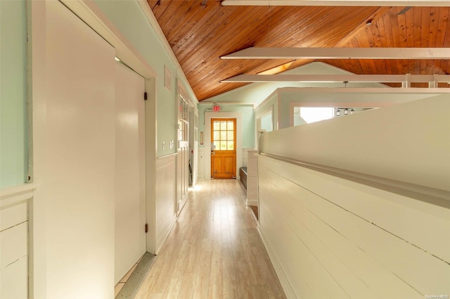 corridor with vaulted ceiling with beams, light hardwood / wood-style floors, and wooden ceiling