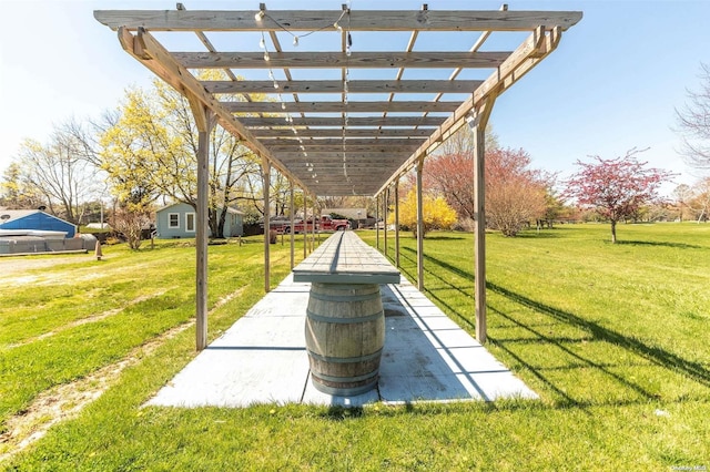 view of property's community with a lawn and a pergola