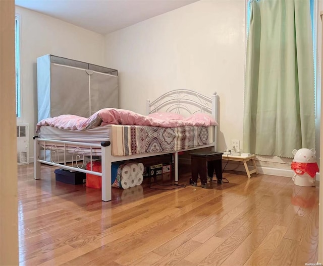 bedroom with hardwood / wood-style floors and radiator