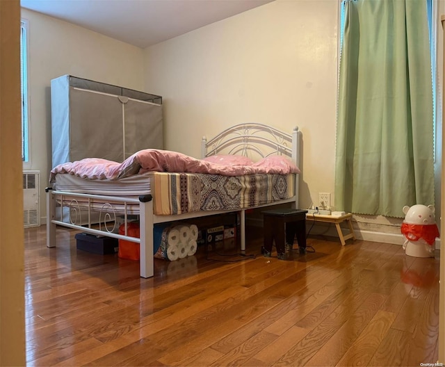 bedroom featuring radiator and wood-type flooring