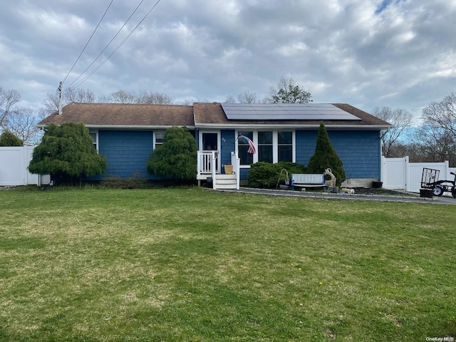 single story home featuring a front lawn and solar panels