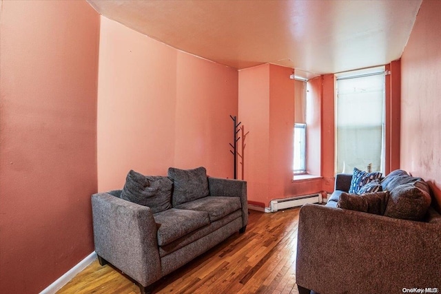 living room featuring wood-type flooring and a baseboard heating unit