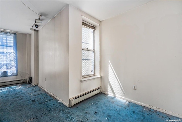 spare room with carpet floors and a baseboard radiator