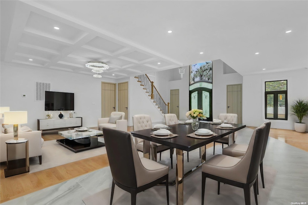 dining room with stairway, light wood-style floors, visible vents, and coffered ceiling