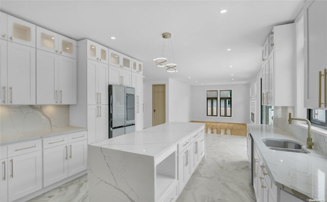 kitchen with sink, white cabinets, stainless steel appliances, and a kitchen island