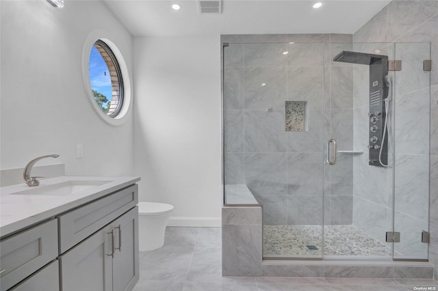 bathroom featuring a shower with door, vanity, and toilet