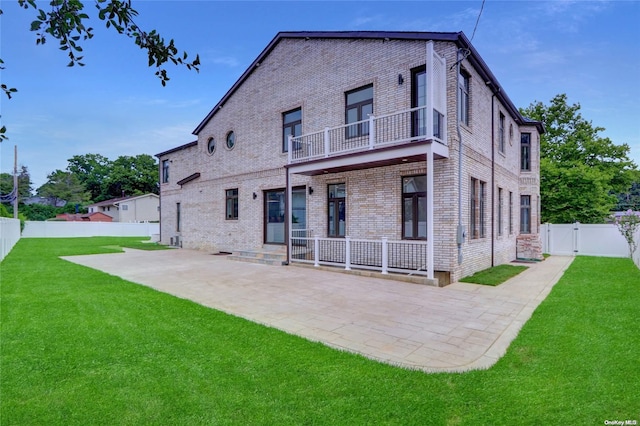 back of house with a lawn, a patio area, and a balcony