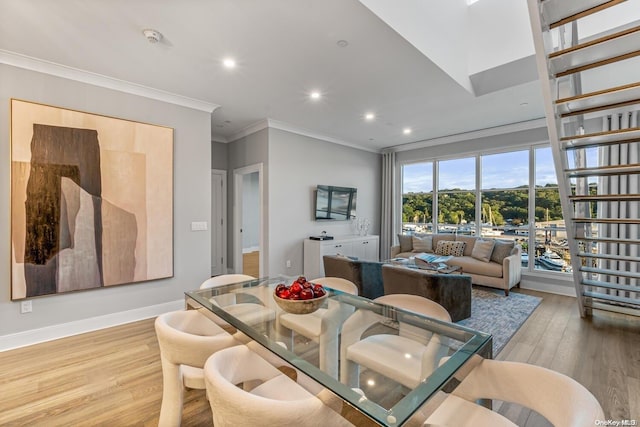 dining space featuring crown molding and light hardwood / wood-style flooring