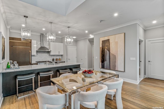 dining room featuring ornamental molding and light wood-type flooring