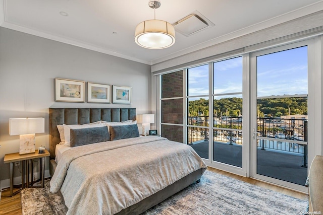 bedroom featuring hardwood / wood-style floors, crown molding, and access to outside