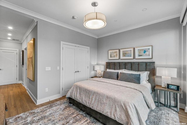 bedroom featuring hardwood / wood-style floors, a closet, and ornamental molding