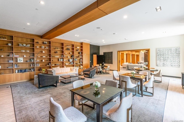 dining room featuring beam ceiling and light wood-type flooring