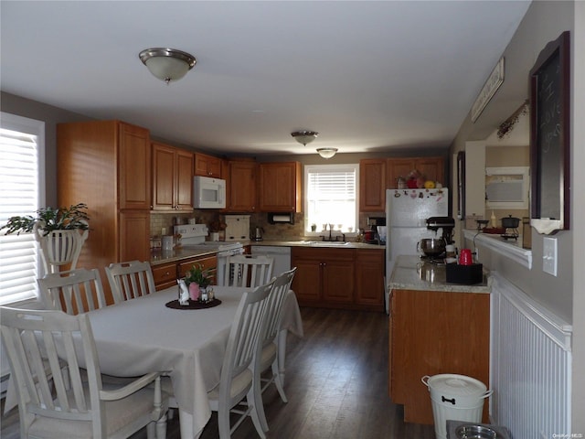 kitchen featuring dark hardwood / wood-style flooring, white appliances, backsplash, and sink