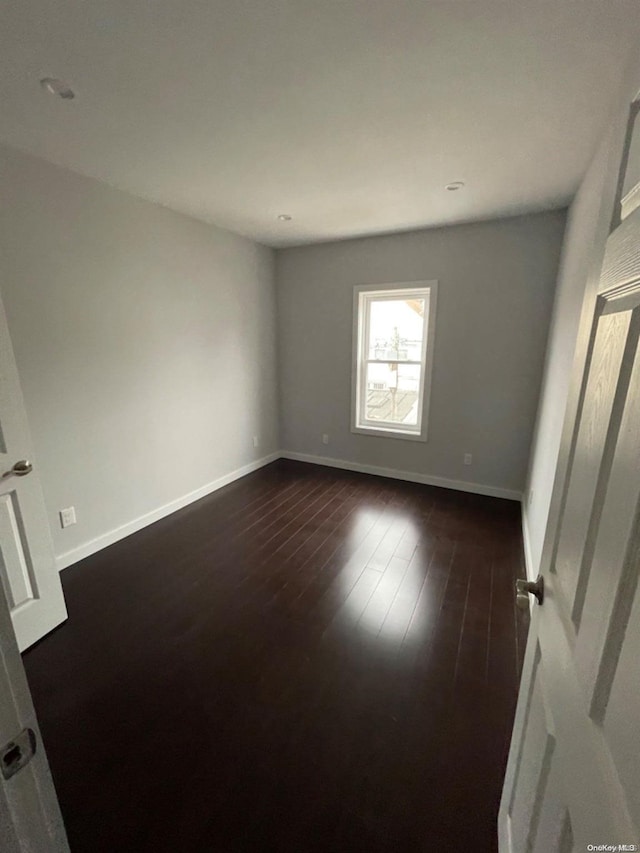 unfurnished room featuring dark hardwood / wood-style floors