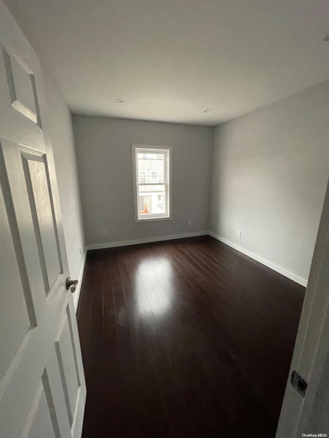 spare room with dark hardwood / wood-style floors