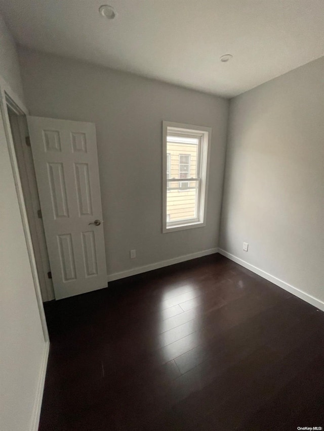 unfurnished room featuring dark hardwood / wood-style flooring