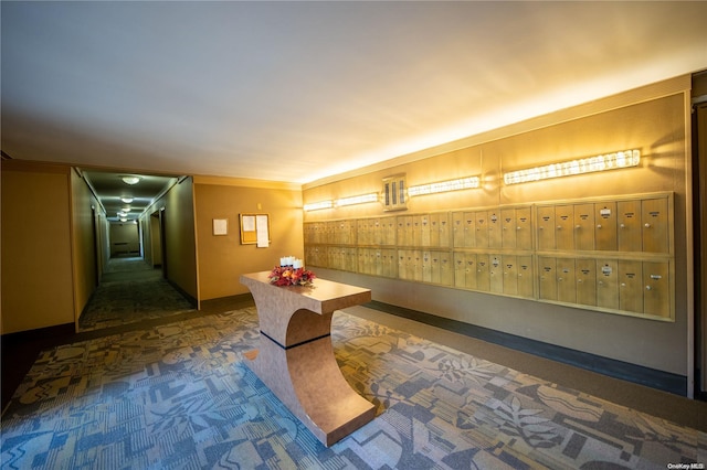 hallway featuring mail boxes, crown molding, and dark carpet