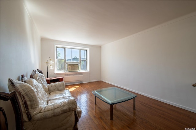 living room with crown molding, radiator heating unit, cooling unit, and wood-type flooring