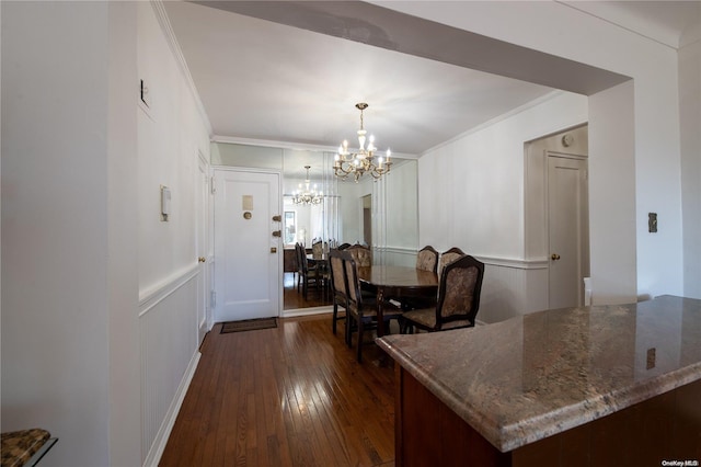 dining room with dark hardwood / wood-style floors, ornamental molding, and a chandelier