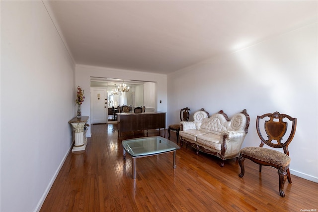 living room with crown molding, hardwood / wood-style floors, and a notable chandelier