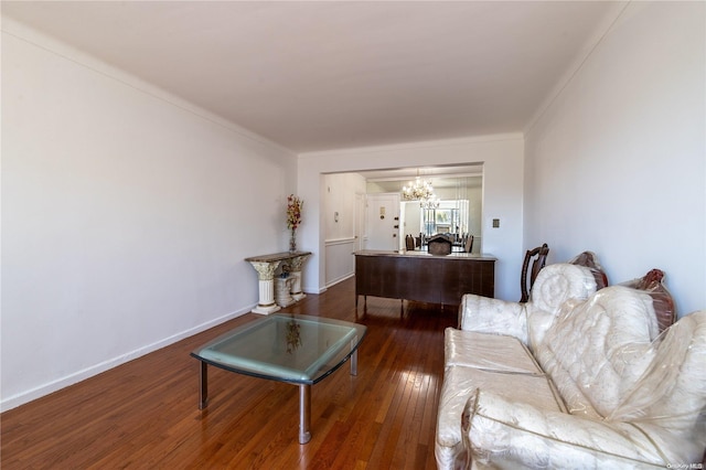 living room featuring crown molding, dark hardwood / wood-style floors, and an inviting chandelier