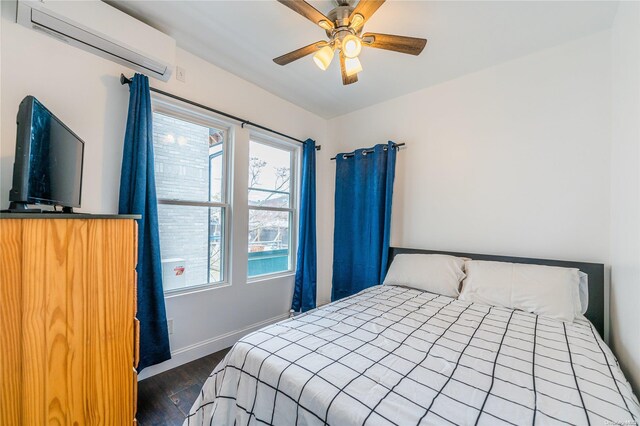 bedroom with ceiling fan, dark hardwood / wood-style flooring, and a wall mounted air conditioner