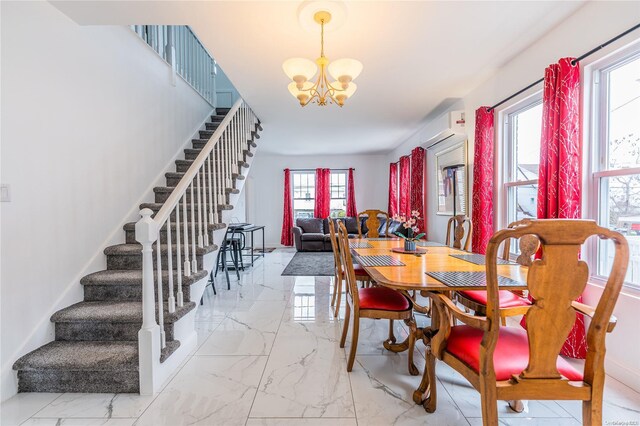 dining space featuring a wall mounted air conditioner, a healthy amount of sunlight, and a chandelier